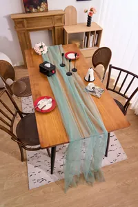 Sage green tulle table runner draped on a wooden dining table for elegant home party decor