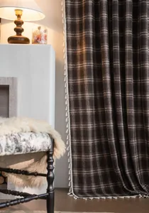 Detailed view of French brown plaid curtain featuring white decorative tassel fringe.
