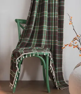 Macro detail of French plaid woolen curtain featuring elegant white fringe border.