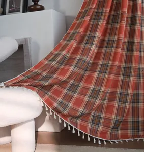 Dettaglio ravvicinato della tenda francese a quadri arancioni con eleganti nappe bianche