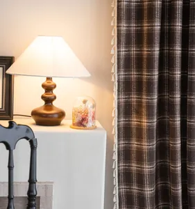 Close-up of coffee plaid French curtain with elegant white tassel fringe in a cozy setting