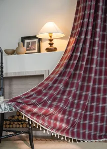 Detailed texture view of red and white plaid wool curtain with elegant white tassel fringe