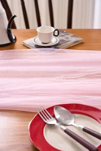 Soft pink tulle fabric table runner for elegant wedding arch and party decorations.