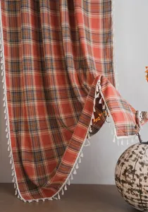 Dettaglio della tenda francese a quadri arancioni con bordi di nappe bianche