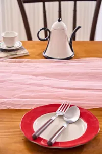 Elegant pink tulle fabric draped over a wooden table for wedding or party decor
