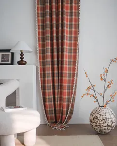 Vista dettagliata delle tende a quadretti arancioni con bordo decorativo a nappe.