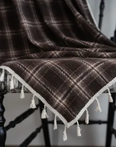 Detailed view of the brown plaid fabric texture and cream tassels on a French style curtain