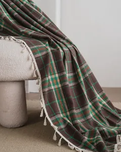 Detailed view of French style brown and green plaid fabric with elegant white tassels
