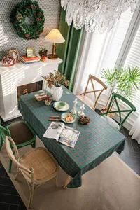 Top view of green and red plaid Christmas tablecloth in a cozy dining room