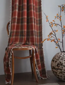 Primo piano di una tenda a scacchi arancione ruggine con eleganti nappe bianche