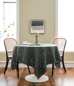 Festive green plaid tablecloth on a round dining table in a cozy home setting.