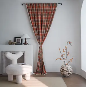 Interno accogliente con tenda a quadretti arancioni e nappe bianche in stile francese