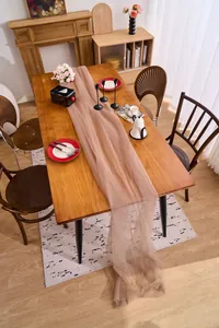 Elegant champagne sheer tulle fabric draped over a wooden table for wedding decor