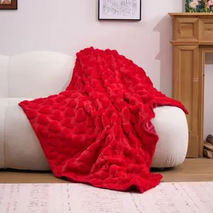 Luxurious red plush blanket featuring a carved heart pattern, elegantly draped on a white sofa