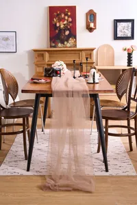 Elegant soft champagne sheer mesh fabric runner draped over a vintage wooden dining table