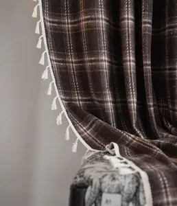 Detailed view of coffee plaid French curtain fabric with elegant white tassel fringe