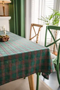 Detail view of a green plaid tablecloth on a cozy dining table with Christmas decor