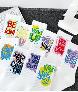 Vue détaillée de chaussettes en coton blanc avec slogans graffiti motivants et colorés.
