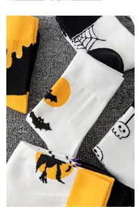 Dettaglio di calzini di Halloween con pipistrelli, ragnatele e teschi su tappeto grigio
