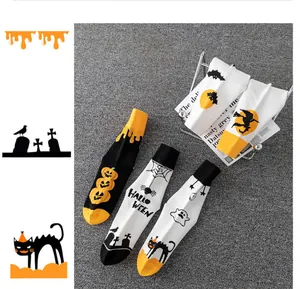 Primo piano di calzini di Halloween a metà polpaccio con motivi di zucche e fantasmi vari.