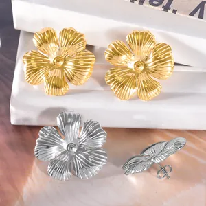 Macro view of elegant metallic flower-shaped stud earrings in gold and silver finishes