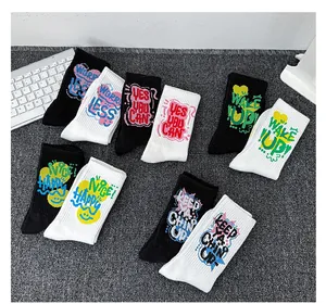 Détail de chaussettes en coton noir et blanc avec des slogans colorés style graffiti