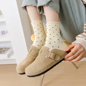 Detailed view of cream-colored polka dot crew socks with a stylish rolled edge design