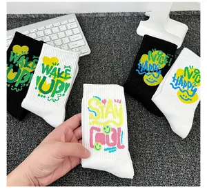 Détail de chaussettes en coton noir et blanc avec slogans colorés et smileys
