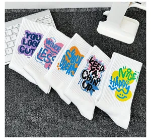 Détail de cinq chaussettes en coton blanc avec des slogans de motivation colorés.