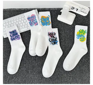 Détail de chaussettes en coton blanc avec des imprimés de slogans colorés de style graffiti