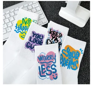 Gros plan de chaussettes en coton blanc côtelé avec motifs graffiti colorés et texte