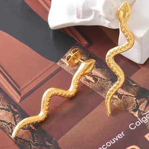 Detailed view of golden snake-shaped titanium steel earrings with scaly texture