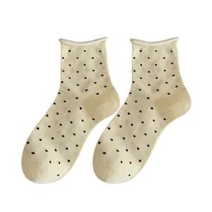 Stylish cream cotton crew socks for women featuring black polka dots and a rolled cuff design