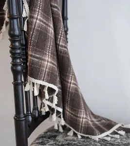 Macro view of French coffee plaid woven curtain featuring decorative white tassels.