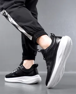Dettaglio delle scarpe sportive da uomo in mesh nero traspirante con suole bianche spesse