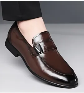 Détail d'un mocassin en cuir marron brillant avec boucle en V et bout noir dégradé.