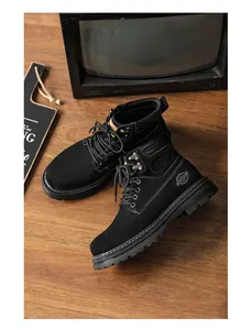Close-up detail of black men's Martin work boots on a rustic vintage wooden surface