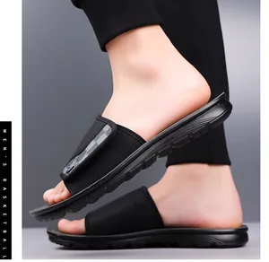 Close-up side view of men's black athletic slide sandals with adjustable velcro strap