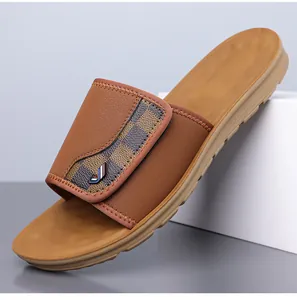 Close-up of men's brown leather slides with checkered pattern strap and metal logo