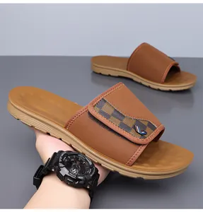 Detailed view of brown men's slide sandals with textured checkerboard strap.