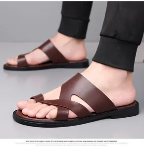Nahaufnahme der braunen Herren-Sandalen aus Kunstleder mit modischem Kreuzriemen-Design.