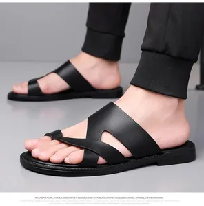 Detailansicht schwarzer Herren-Sandalen mit Kreuzriemen und modischem Zehenring.