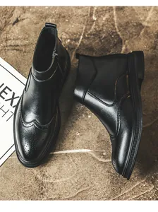 Top view of black leather Brogue boots for men with vintage wingtip carving detail