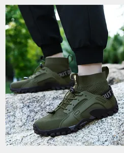 Vista laterale di scarpe da ginnastica outdoor alte verde oliva su terreno roccioso