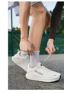 Detail of white men's lightweight racing running shoes in a sporty outdoor track setting