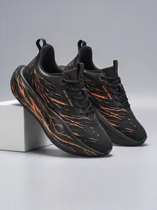 Close-up van zwarte heren hardloopschoenen met oranje vlampatronen en ademend mesh textuur.