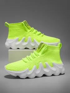 Close-up of neon green knit running shoes with a unique wavy white thick sole