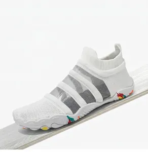 Close-up of white breathable water shoes with non-slip soles on a wooden surface.