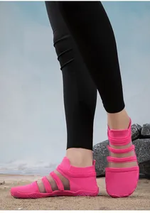 Vibrant pink mesh quick-dry water shoes for beach and swimming, worn by model on sand
