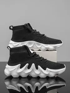 Close-up of black high-top flyknit sneakers featuring unique white wavy flame outsoles